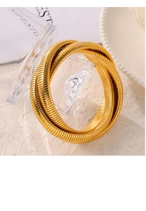 Nahaufnahme des goldenen mehrlagigen Schlangenknochen-Armbands mit glänzendem Metall-Finish