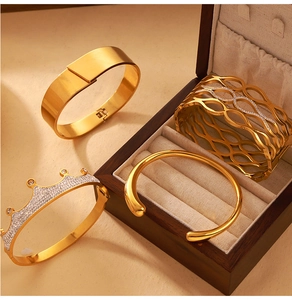Close-up of gold crown bangle and stacking bracelets in a luxury jewelry box set