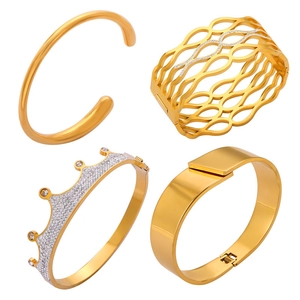 Set of four gold-plated stainless steel bangles featuring crown and hollow diamond designs