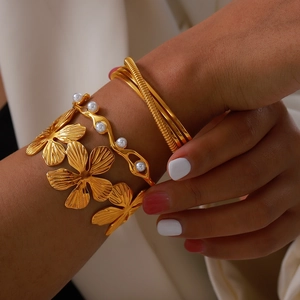 Gold layered flower bangle set with white pearls and open floral cuff for women