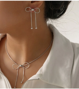 Macro detail of silver butterfly bow jewelry set featuring sleek snake chain design