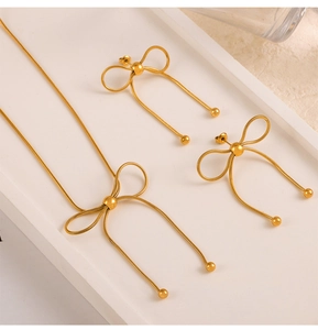 Detail of gold butterfly jewelry set featuring snake chain texture and polished beads