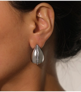 Macro shot of silver teardrop earrings with a central row of sparkling crystals
