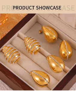 Close-up of gold-plated teardrop earrings with shimmering diamond inlay in a jewelry box