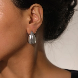 Elegant matte silver teardrop earrings with vertical zircon pavé setting on model