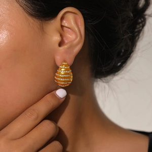 Elegant gold-plated teardrop earrings with rows of sparkling crystals on female model