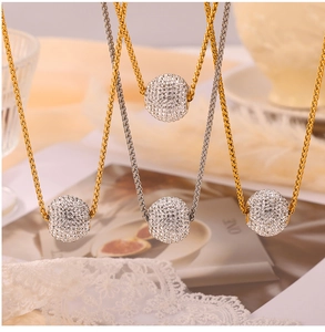 Détail macro de chaînes Chopin or et argent avec pendentifs boules pavés de cristaux