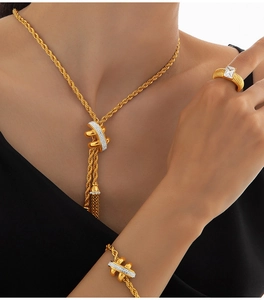Close-up of golden rope chain jewelry set with necklace, bracelet and ring details