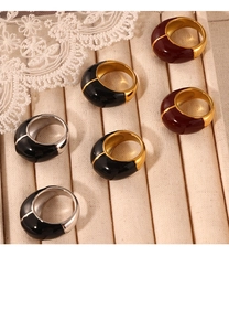 Détails macro de bagues en émail rouge et noir sur un plateau à bijoux beige