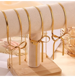 Vista dettagliata di un set di collana e bracciale a fiocco dorato su supporto in velluto