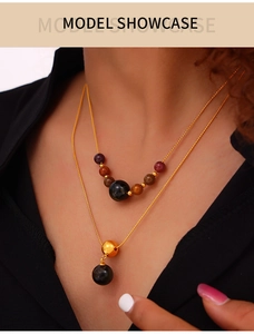 Close-up of layered tiger eye stone necklace with gold titanium chain on model