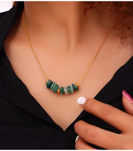 Close-up of vintage tiger eye stone necklace on a black shirt worn by a model