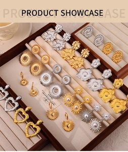 Détail des boucles d'oreilles tournesol en or 18 carats et argent sur un plateau