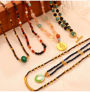 Detail of layered handmade necklaces with natural stones, malachite, and gold pendants