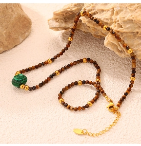 Detail of natural tiger eye and green malachite beads with golden titanium steel clasp