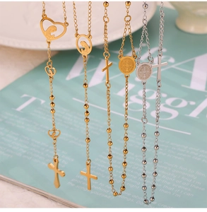 Primer plano de collares religiosos con cruces doradas y colgantes de la Virgen María