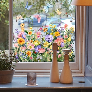Dettaglio di adesivi per finestre con fiori colorati e farfalle su vetro in pieno sole