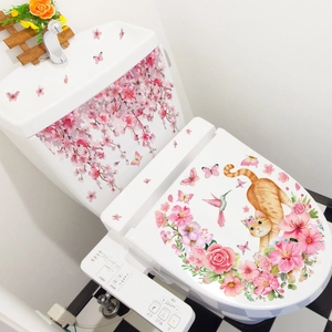 Détail des stickers fleurs roses et décor de chat mignon sur des toilettes blanches