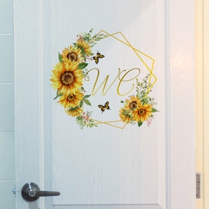 Detail of sunflower door sticker with golden WC lettering for bathroom decor