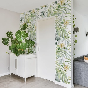 Macro detail of tropical palm leaves and floral wallpaper decals on a white wall