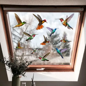 Close-up of colorful hummingbird window clings set on glass with natural forest background