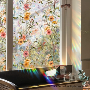 Close-up of static window film with floral and bird patterns creating rainbow light effects