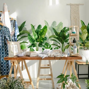 Papier peint adhésif feuilles tropicales vertes dans un décor de studio nordique