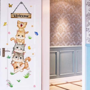 Detail van de cartoon katten muurstickers op een witte houten deur met een welkomstbordje