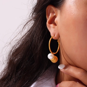 Fashion gold hoop earrings with white pearl and hammered sphere pendant on model