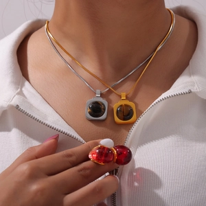 Ensemble minimaliste en titane avec pendentifs et bague rouge sur haut blanc côtelé
