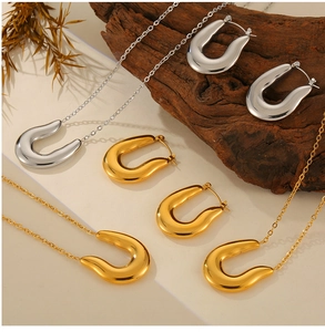Detailed view of U-shaped horseshoe gold and silver jewelry set on dark wood background