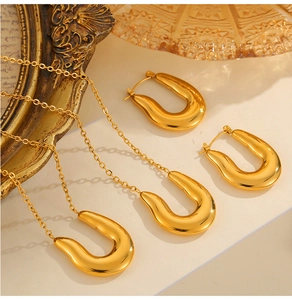 Detailed view of polished 18k gold plated U-shaped necklace and matching earrings set