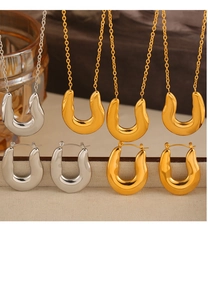 Macro view of minimalist U-shaped 18k gold and silver necklaces and earrings set