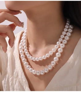 Close-up of double-layer high-luster pearl necklace on model showing elegant round beads