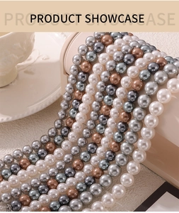 Detailed close-up of high-luster white, grey and champagne pearl necklaces on a display stand
