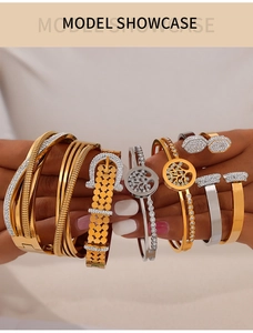 Détail de bracelets superposés plaqués or et argent avec zircons et design en forme de clou