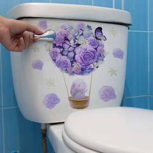 Détails de stickers fleurs violettes et lapin sur un réservoir de WC pour la déco