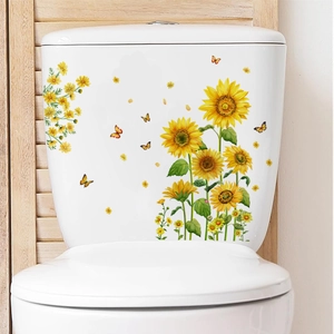 Détail de stickers tournesol et papillon sur la surface blanche du réservoir de toilette