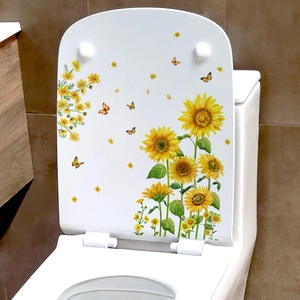 Détail de stickers tournesols et papillons sur l'abattant d'un WC blanc moderne