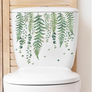 Détail de stickers aquarelle de plantes vertes sur un réservoir de toilettes en céramique