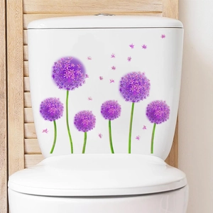 Détail des stickers fleurs violettes sur un réservoir de toilettes blanc en céramique