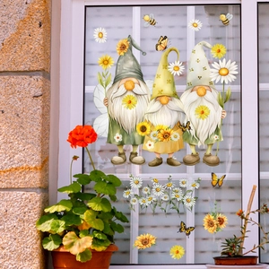 Detail view of sunflower gnomes and bee window decals on glass with potted plants