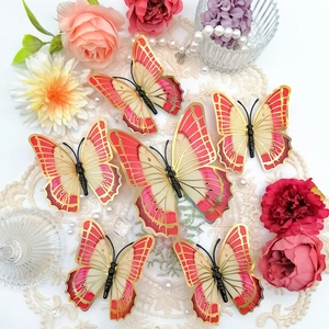 Detailed view of 3D layered butterflies with gold hollow edges on lace and flowers