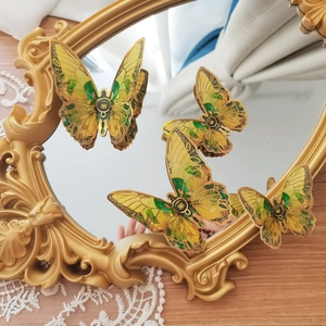 Detailed view of yellow and green 3D butterfly wall stickers with gold edges on mirror