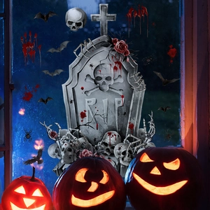 Close-up of Halloween window decals featuring gravestones, bats and skeletons at night