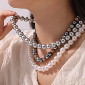 Three-layer layered pearl necklace featuring white, grey, and multicolor round beads