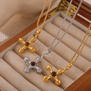 Retro gold and silver cross necklaces with tiger eye stones on rope chains in a jewelry box