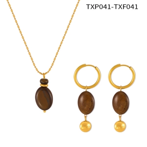 Detail of tiger eye oval pendants on gold-plated necklace and earrings set with Lucky charms