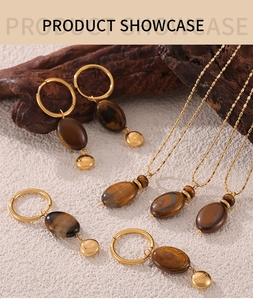 Detail of vintage 18k gold tiger eye jewelry set with Lucky charms on stone textures