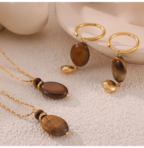 Detailed set of 18k gold plated necklaces and tiger eye earrings with lucky charm